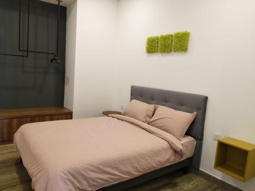 怡保八角形怡保公寓的一间卧室配有一张挂着绿色画作的床铺。