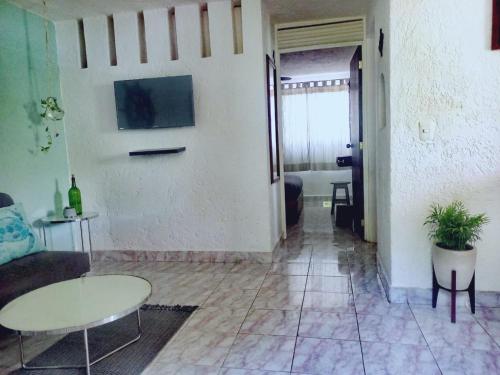 坎昆Mi Otoch en Cancun jardín terraza asador的客厅配有沙发和桌子