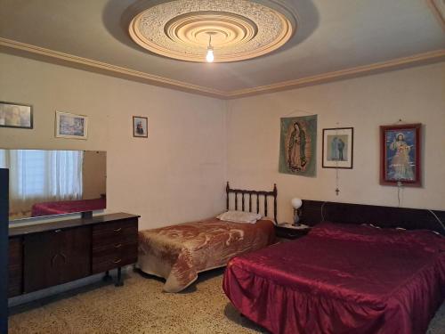 Ciudad NezahualcóyotlCasa Martha的一间卧室设有两张床和大镜子