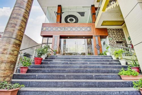 Vibhuti KhandTownhouse OAK Hind Palace Near Gomti Riverfront Park的一座种植盆栽植物的建筑前的一段楼梯