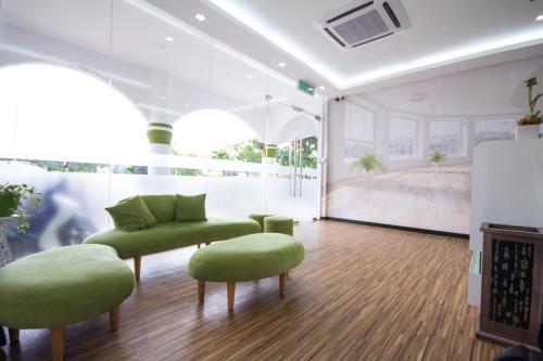 北赖S Hotel Seberang Jaya的一间设有两张绿色椅子和一张沙发的房间