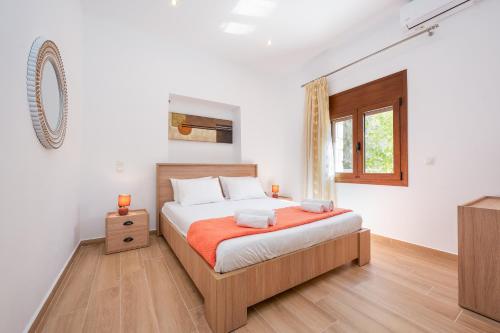 爱琴娜岛Villa Estrella的一间卧室设有一张床、一个窗口和一台电视