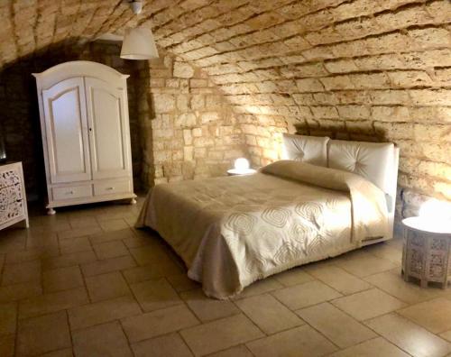 巴里Dimora Pietra Antica的一间卧室设有一张床和石墙