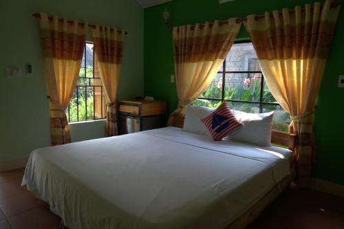 峰牙Greenfield Ecostay的卧室配有白色的床和2扇窗户。