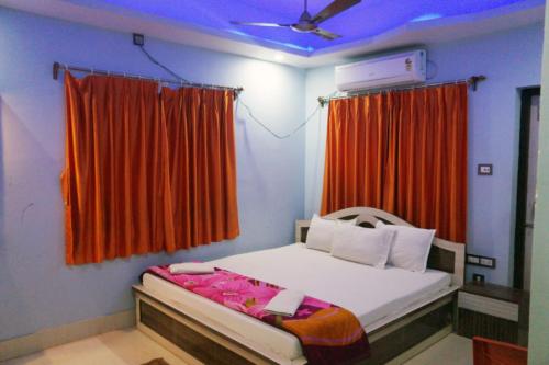 迪卡Goroomgo Muskan Guest House Digha的一间卧室配有一张带红色窗帘的床