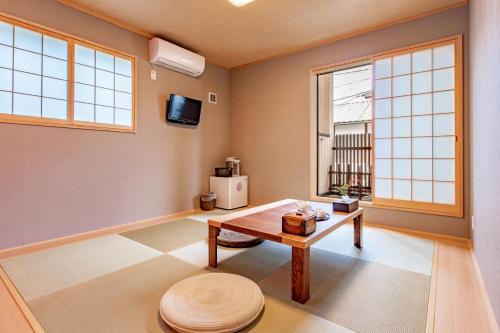 ShimmachidōriKyoto KaedeHotel Kamogawa的客厅配有桌子和2扇窗户