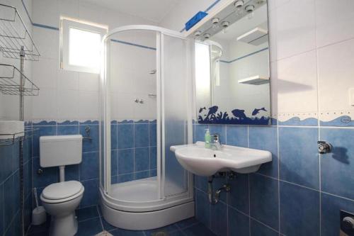 希洛Apartmani Zec的蓝色瓷砖浴室设有卫生间和水槽