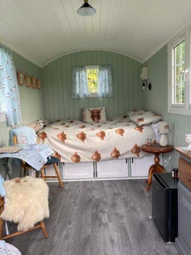 金斯林钟声草甸牧羊人小屋露营地的卧室配有一张床和一张桌子及椅子