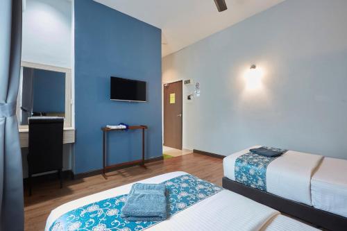 关丹D' Qamar Guesthouse的酒店客房设有两张床和蓝色的墙壁。