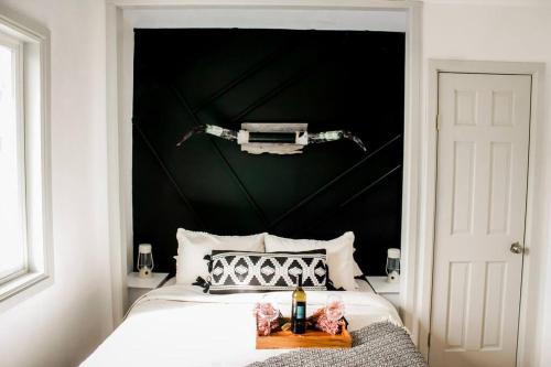 克拉马斯福尔斯The Shasta Cottage的一间卧室配有黑色床头板和白色的床