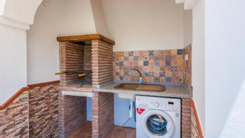 AlmácharCasa Tortela Almáchar by Ruralidays的小厨房配有洗衣机和烘干机,厨房配有水槽