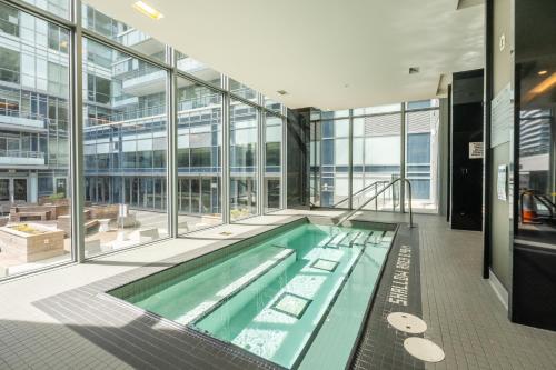 多伦多Modern Lillian St Apartments by GLOBALSTAY的一座大型游泳池,位于一座带窗户的建筑内
