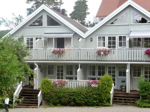 克拉格勒Bergland apartment 18 - close to the center of Kragerø的白色的房子,阳台上放着鲜花