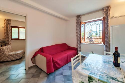 马里纳迪马萨WELLNESS VERSILIA -SAUNA & JACUZZI- Free Parking-的客厅配有红色的沙发和玻璃桌