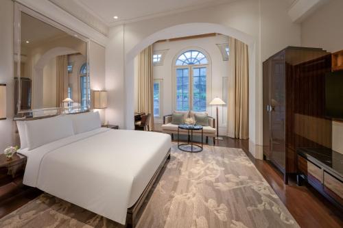 新加坡The Capitol Kempinski Hotel Singapore的一间带白色大床的卧室和一间客厅
