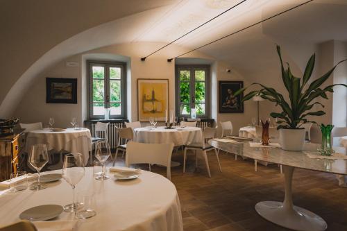 克罗诺奥赛里VILLA MANZONI的餐厅设有白色的桌椅和窗户。