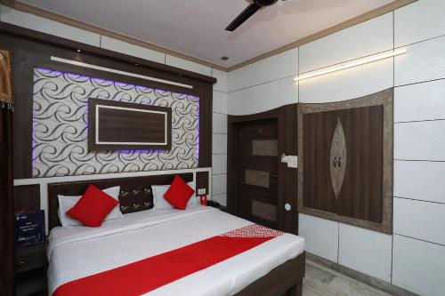 阿格拉OYO Hotel Vanshika的一间卧室配有一张带红色枕头的床和一台电视。