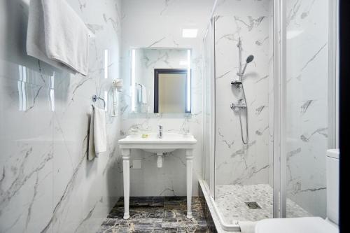 敖德萨皇家大街酒店的白色的浴室设有水槽和淋浴。