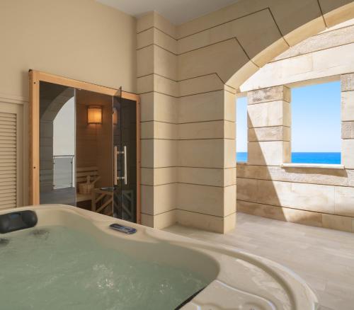 罗希姆诺马卡利斯套房酒店及Spa的带浴缸的浴室和窗户
