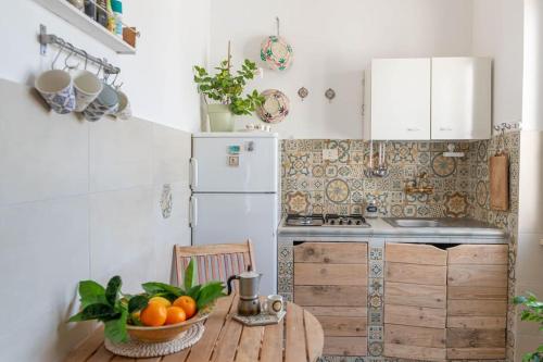 蓬扎~ ~ Brezza Mediterranea ~ ~的厨房配有带一碗橙子的木桌