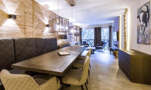 萨尔巴赫AvenidA Mountain Lodges Saalbach的用餐室配有大型木桌和椅子