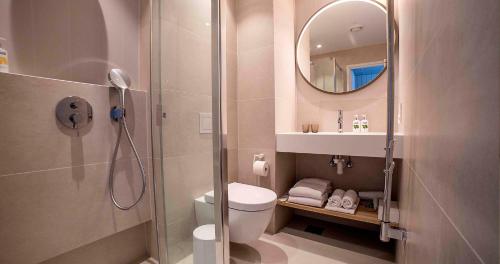 劳拉斯玛LaSpa Beach House的带淋浴、卫生间和镜子的浴室