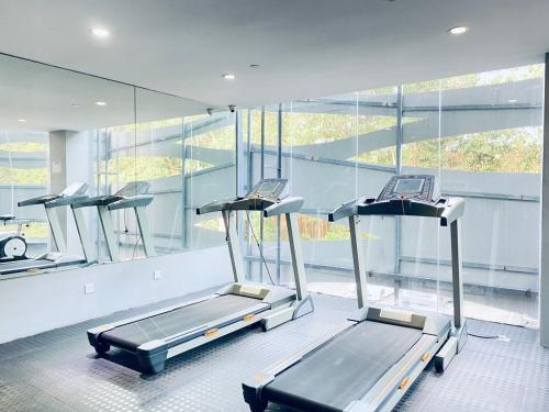 雪邦斯里浪憶酒店的一间健身房,里面设有三台跑步机,房间设有窗户