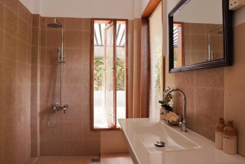 米瑞莎The Secret Guesthouse的一间带水槽、镜子和淋浴的浴室