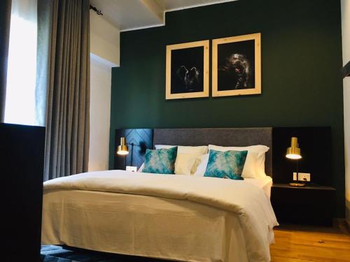 努沃勒埃利耶The Greens Luxury Apartment的卧室配有一张大床,墙上挂有两张照片
