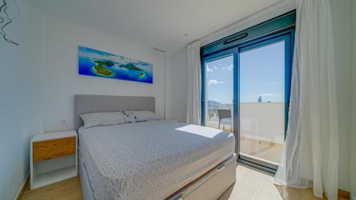菲内斯特拉特Duplex Finestrat的一间卧室设有一张床和一个大窗户