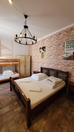 华沙Hostel Chmielna 5 Rooms & Apartments的砖墙客房内的一张大床