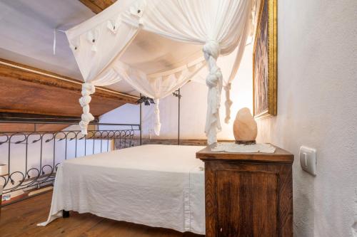 VetuloniaIl Casale La Duchessa的卧室配有带白色窗帘的天蓬床