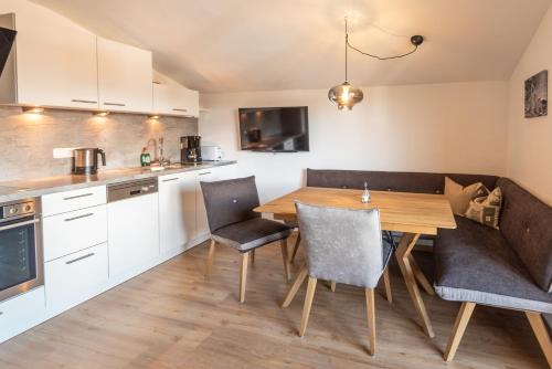 基茨比厄尔Apartments Foidl的厨房以及带木桌和椅子的用餐室。
