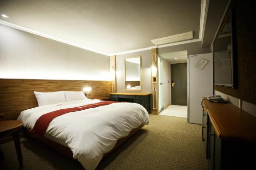 大邱Ariana Hotel的酒店客房设有一张大床和一间浴室。