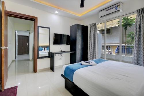 浦那StayBird - Silver Oak, An Apartment Hotel, Kharadi的一间卧室设有一张床和一个大窗户