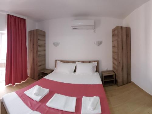 科斯蒂内什蒂Vila Aren的一间卧室配有一张大床,铺有红白毯子