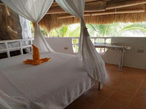 布桑加AL FARO Cosmio Hotel Palawan的卧室配有一张带蚊帐的白色床