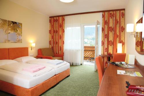 安格安格勒霍夫酒店的配有一张床、一张书桌和一扇窗户的酒店客房