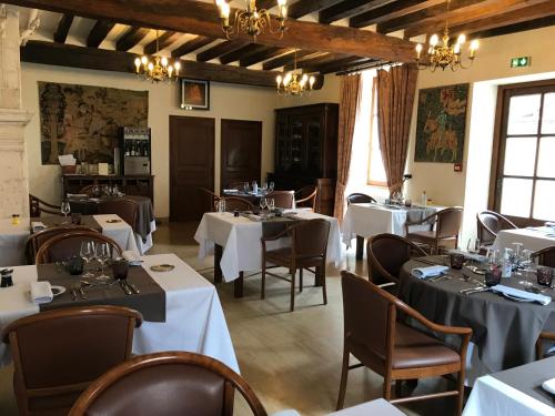 Ligny-le-ChâtelLOGIS HOTEL - Le Relais Saint Vincent的餐厅设有白色的桌椅和窗户。