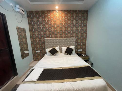 GulzārbāghHotel Glance Inn的一间卧室设有一张大床和墙壁