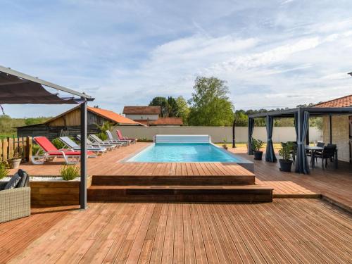 利和米克斯Holiday Home Petrocq - LIT120 by Interhome的房屋旁的木甲板上的游泳池