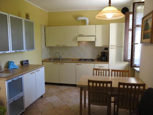 卡斯塔诺兰泽Holiday Home I Grilli by Interhome的厨房配有白色橱柜和桌椅