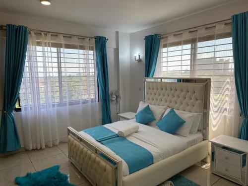 基苏木Nyachaba Apartment的一间卧室配有一张带蓝色和白色枕头的床