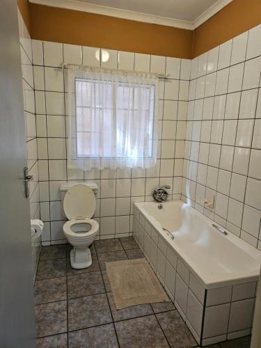 波罗瓜尼Motel Villa Africa的一间带卫生间和浴缸的浴室以及窗户。