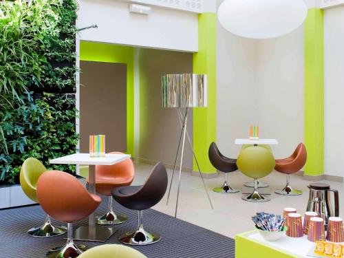 梅里尼亚克宜必思尚品波尔多机场酒店的一间设有桌椅和绿色墙壁的客房