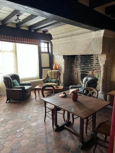布鲁瓦Maison des Acrobates的客厅配有桌子和壁炉