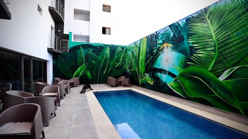 梅克内斯HOTEL BELLE VUE MEKNES的一座植物壁画建筑中的游泳池