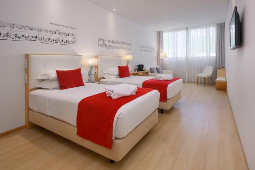 波尔图达达音乐酒店的两张床铺,位于酒店客房,墙上有音乐