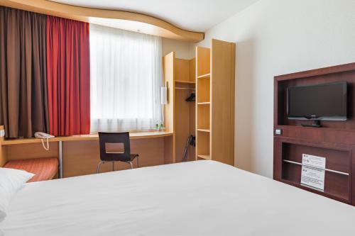 华沙华沙雷杜塔宜必思酒店的一间酒店客房,配有一张床和一台电视