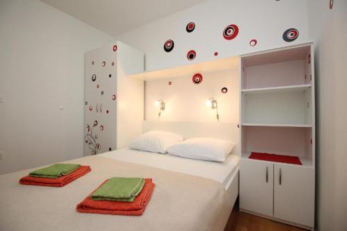 希洛Apartmani Zec的一间卧室配有一张带红色毛巾的床